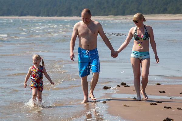 Eine Familie spaziert am Sandstrand