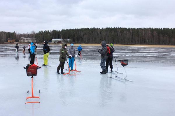 Menschen mit Tretschlitten auf dem Eis des Sees Võrtsjärv beim Pläneschmieden