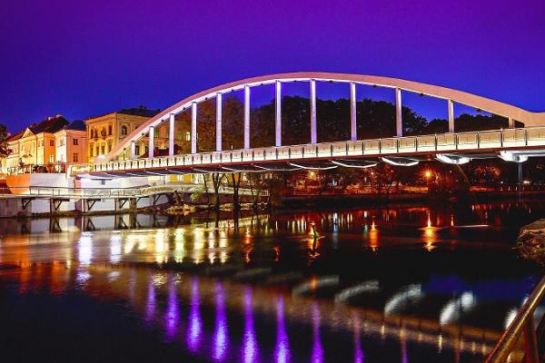 Die Bogenbrücke im Licht eines Sommerabends, das Licht spiegelt sich im Emajõgi (dt. Embach)