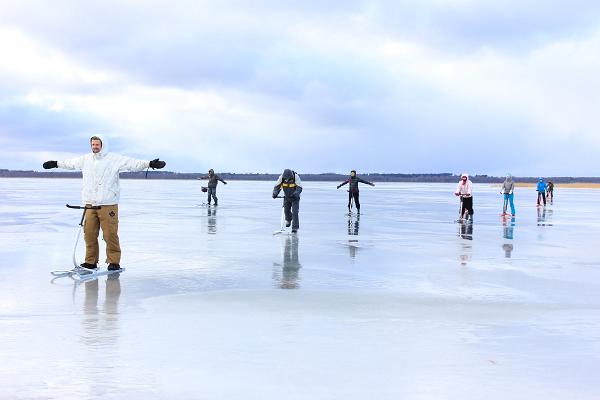 Menschen mit Tretschlitten auf dem Eis des Sees Võrtsjärv