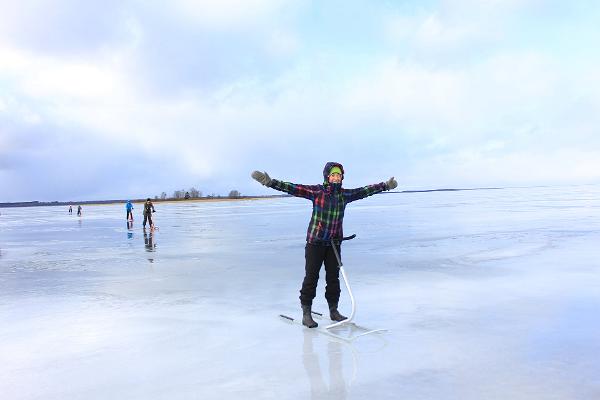 ein Mädchen mit einem Tretschlitten auf dem Eis des Sees Võrtsjärv