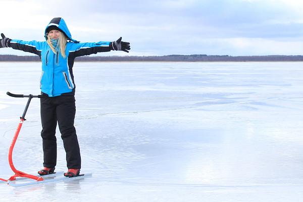 Meitene zilā jakā ar stumjamām ragavām uz Vertsjerves ezera ledus