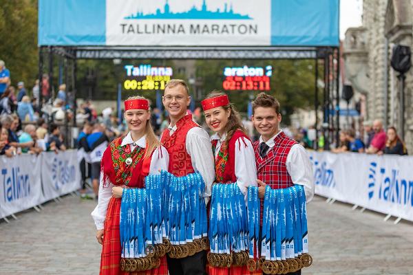 Молодежь в национальных костюмах с медалями Таллиннского марафона