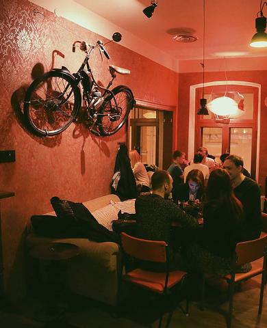 Bar Trepp und ein gemütliches Interieur, an der Wand ein Motorrad, Menschen verbringen ihre Zeit.