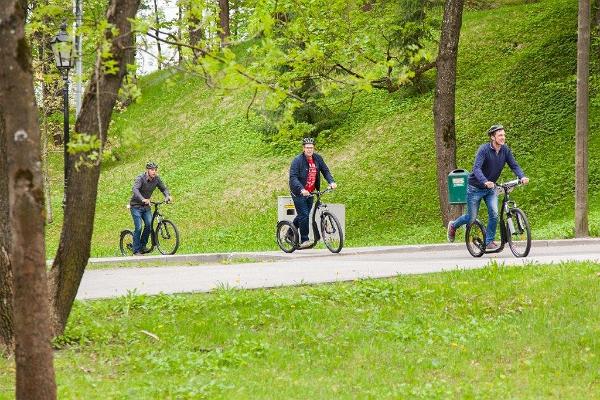 Приключение на самокатах в городе Тарту: люди на велосипедах в зеленом Тарту