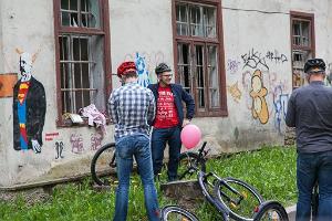 Sparkcykel äventyr i staden Tartu: cyklister tittar på gatukonst i Tartu