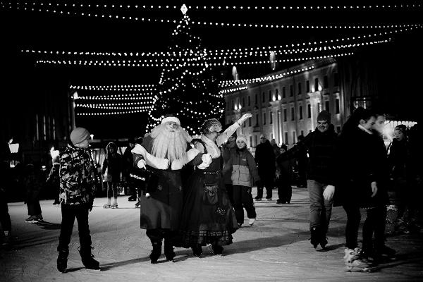 Радостные люди, катающиеся на коньках на катке в центре города Тарту
