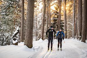 Skipisten des Gesundheitssportzentrums des Landkreises Tartu und Skifahrer am sonnigen Tag