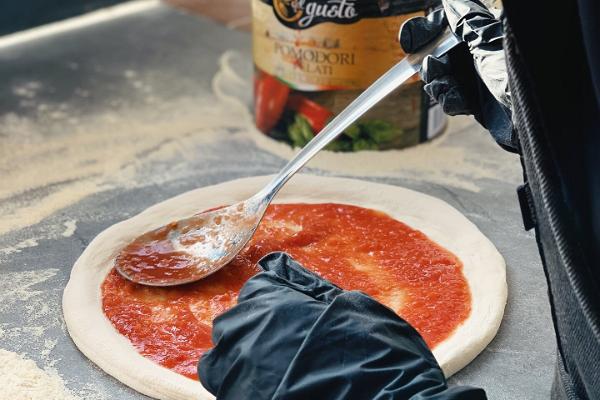 Hütt-kotiravintolan pitsan valmistuksen työpaja – pitsan laittamista uunivalmiiksi