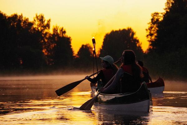 A canoe trip in the night glow of torches