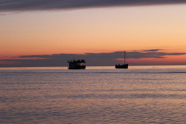 Toilas merel puulaev Tütarsaare Aino ja Meresaun päikeseloojangu taustal