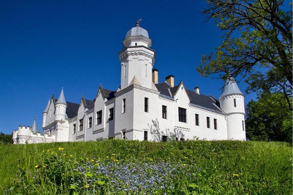 De vita sagolika slottet i sommargrönskan av Lökvägen