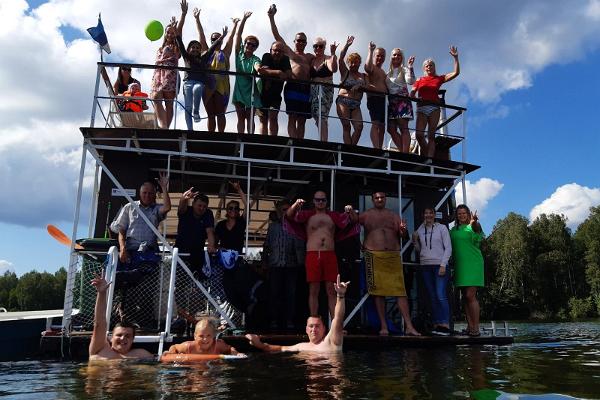 Lyckliga bastuentusiaster på bastuflotten på sjön Saadjärv