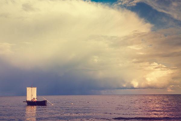 Ninan olkitalojen perinteinen vene auringonlaskun aikana