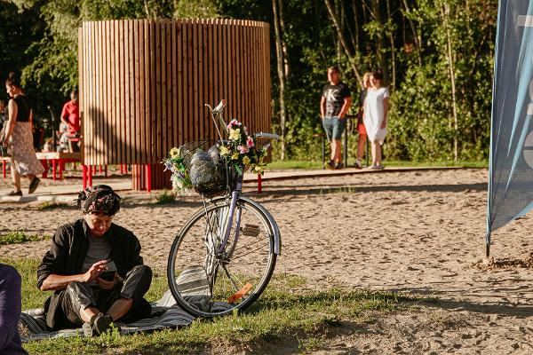 Городской пляж на реке Эмайыги, кабинка для переодевания и отдыхающий с велосипедом