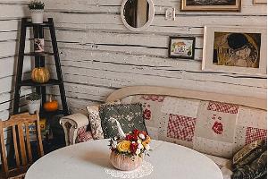 Valge Kõrvitsa hubane interjöör, diivan, laud ja toolid, pildid seinal