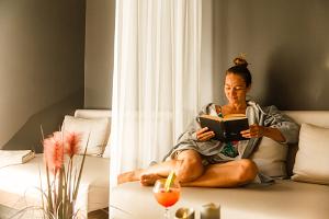 Eine Buch lesende Frau im Entspannungsbereich Sauna-Oaas (18+) (dt. Sauna-Oase) 
