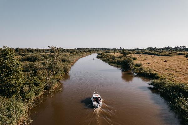 Pildil Kiviranna puhkemaja mootorpaadiga jõel sõitvad inimesed