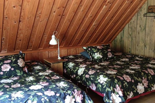 Det lilla sovrummet med breda sängar - Marknagårdens semesterstugas Paulis härbre. Bebissäng.