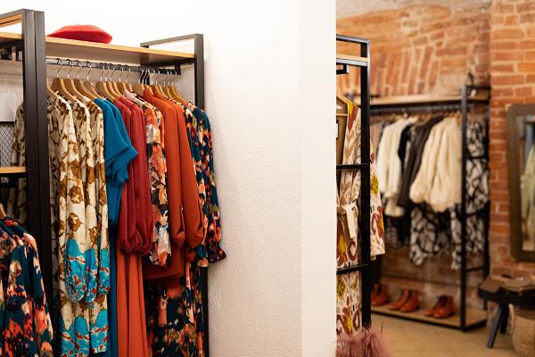 patterned clothes in red and bluish tones hanging in a clothing store
